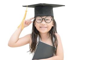 asiatique école enfant diplômé en pensant et sourire avec l'obtention du diplôme casquette isolé photo