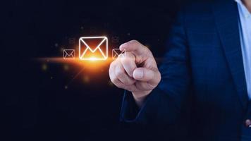 homme d'affaires détenant la vérification des e-mails en ligne avec la technologie d'interface virtuelle. marketing direct, message en ligne, e-mail, courrier électronique, concept de communication. photo