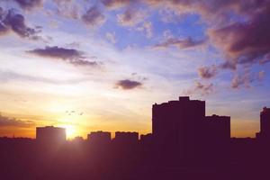 ville horizon avec bâtiments silhouettes dans le coucher du soleil ciel photo