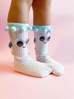 bébé chaussettes avec yeux et sourire sur rose Contexte photo