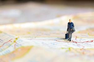 homme d & # 39; affaires miniature debout sur la carte, concept de voyage photo