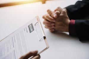 homme d'affaire ou emploi chercheur la revue le sien reprendre sur le sien bureau avant envoyer à découverte une Nouveau emploi avec stylo, cravate, des lunettes et numérique tablette. photo