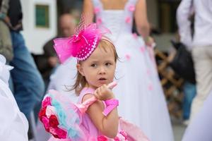 les mariées parade. marrant peu fille dans avec une bouquet de fleurs à une mariage. photo