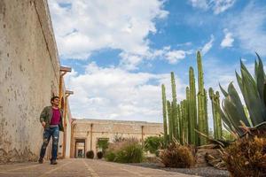 homme visite le vieux rustique modèle école avec cactus dans minéral de pozos guanajuato Mexique photo