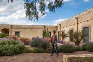 homme visite le vieux rustique modèle école avec cactus dans minéral de pozos guanajuato Mexique photo