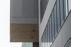 Fragment de bâtiment en béton gris avec des fenêtres vides photo