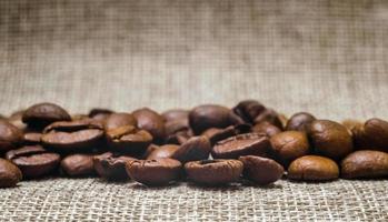 De nombreux grains de café sur un tapis, fond beige macro, Close up