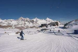 arrière vue de skieur ski sur neigeux paysage en dessous de ciel photo