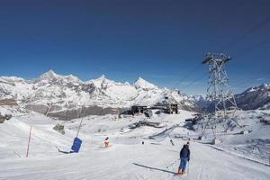 arrière vue de skieur avec poteaux ski sur neigeux paysage photo