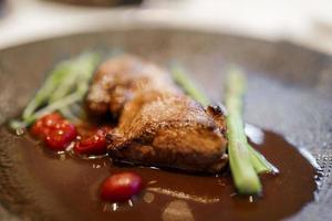 Viande avec Cerise tomates et céleri servi dans assiette à luxe restaurant photo