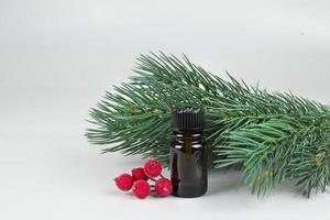 petit marron cosmétique bouteille avec Noël arbre branches et rouge Noël des trucs sur lumière Contexte photo