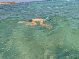 garçon plongée dans le mer dans bleu l'eau sur une été chaud vacances journée photo