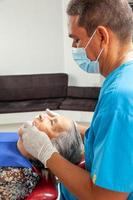 Sénior femme patient à une Masculin milieu -vieilli dentiste Bureau photo