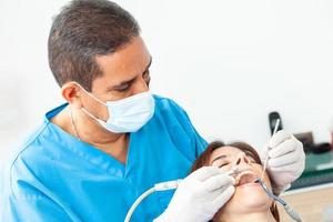 Masculin âge moyen dentiste à le sien Bureau avec une femelle patient photo