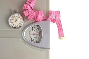 sol Balance, chronomètre et mesure ruban sur une blanc background.weight perte et des sports. photo