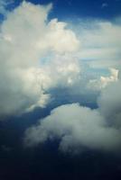 blanc des nuages contre le bleu ciel vu de le vol de le les fenêtres de le avion photo