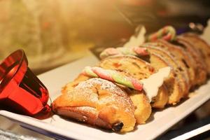 rouge cloche avec pains tranche et beurre gâteau est fait maison sur tisser plateau dans boulangerie magasin. Noël et Nouveau ans fête photo