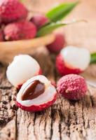 moitié Frais biologique litchi fruit sur bois photo