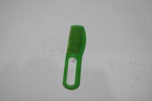 photo de une vert cheveux peigne fabriqué de Plastique avec une blanc Contexte