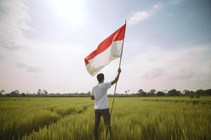 une homme en portant une rouge et blanc Indonésie drapeau sur Haut de une luxuriant vert riz champ. ai généré photo