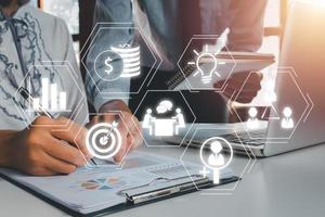 conformité virtuel diagramme pour affaires une analyse données, deux collègues discuter Les données avec document Les données et Nouveau moderne ordinateur portable sur bureau tableau. photo