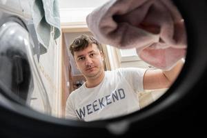 homme vue de la lessive machine à l'intérieur. Masculin Est-ce que blanchisserie du quotidien routine. photo