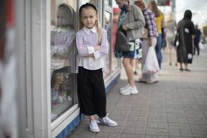 une peu fille contre le toile de fond de ville ameublement et vitrines. photo