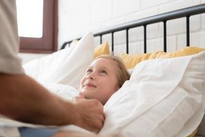 avant sortant à nuit, une père exprime le sien affection par embrasser le sien fille sur le front. à avoir une bien nuits du repos photo