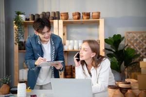 une Jeune couple court une petit affaires fabrication argile bijoux. elles ou ils soutien un un autre comme elles ou ils travail vers devenir plus grande affaires dans le avenir. photo