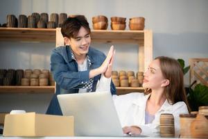 une Jeune couple court une petit affaires fabrication argile bijoux. elles ou ils soutien un un autre comme elles ou ils travail vers devenir plus grande affaires dans le avenir. photo