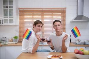 lgbt Jeune couple célébrer le journée de l'amour entre chaque autre avec bien du vin dans le cuisine de le maison photo