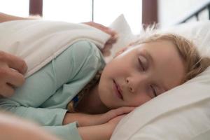 une père jouit parlant avec le sien fille dans le sien chambre à coucher. avant en disant Au revoir et Envoi en cours sa fille à lit photo