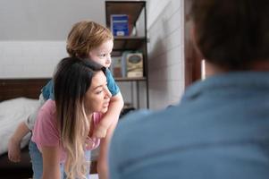 après le peu garçon se réveille en haut de le sien sieste, le sien père et mère engager dans agréable Activités dans le sien chambre à coucher. photo