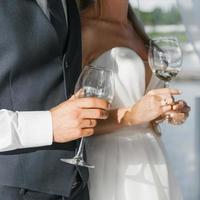 Champagne des lunettes dans le mains de le la mariée et jeune marié fermer photo