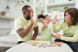 père, mère, et un enfant repos et ayant amusement ensemble tandis que sur vacances à maison. photo