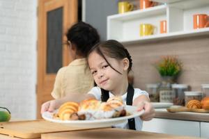 portrait de une peu les filles dans le cuisine de une maison ayant amusement en jouant cuisson pain photo