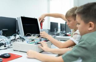 jeunes utilisant le main robot La technologie sont ayant amusement apprentissage le électronique circuit planche et main robot manette de robot technologie, lequel est un de le tige cours. photo