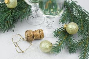 Nouveau années photo une Liège de Champagne et une muzel, une Noël arbre branches, d'or Noël des balles et des lunettes de Champagne