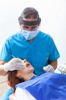 Masculin âge moyen dentiste à le sien Bureau avec une femelle patient photo