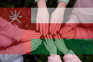 mains de des gamins sur Contexte de Oman drapeau. omanais patriotisme et unité concept. photo