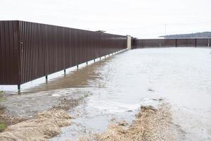 printemps inonder dans rural zones - inondation de le rivière, inondation de maison territoires derrière le clôture. le éléments après le fusion de neige et lourd des pluies photo