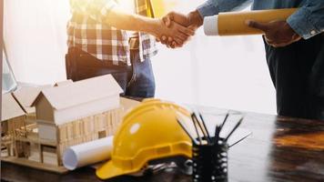 deux hommes d'affaires ingénieur de chantier. objets d'ingénierie sur le lieu de travail avec des partenaires interagissant en arrière-plan photo