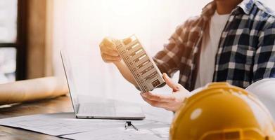 deux hommes d'affaires ingénieur de chantier. objets d'ingénierie sur le lieu de travail avec des partenaires interagissant en arrière-plan photo