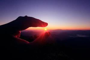 femme les doigts choisir magnifique Soleil dans Naturel crépuscule de le coucher du soleil sur le Montagne photo