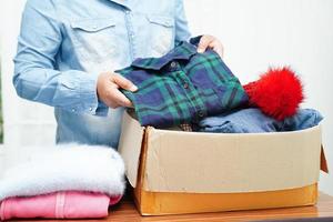 dons de vêtements dans une boîte en carton pour les bénévoles. photo