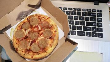 bureau de travail avec une pizza savoureuse photo