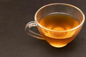 verre tasse de chaud gingembre thé sur le noir bureau. photo