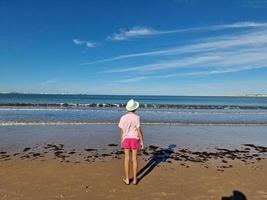 fille avec chapeau dans de face de le mer, sur une sablonneux plage. valdelagrana plage photo