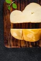 fromage scamorza fumé saveur Frais nourriture casse-croûte sur le table copie espace nourriture Contexte rustique Haut vue photo