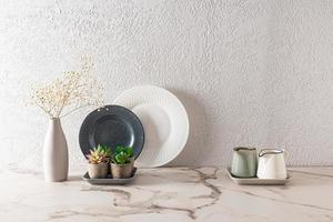 élégant cuisine Contexte avec contrastant foncé et lumière vaisselle sur une marbre comptoir. minimaliste style dans le conception de le cuisine espace. photo